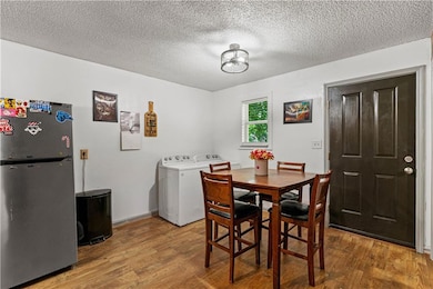 Dining room with wood finished floors, a textured ceiling, and washer and clothes dryer