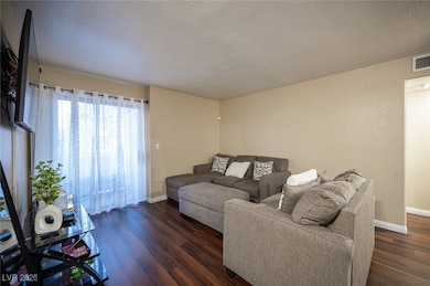 Living room featuring dark wood-style flooring, a