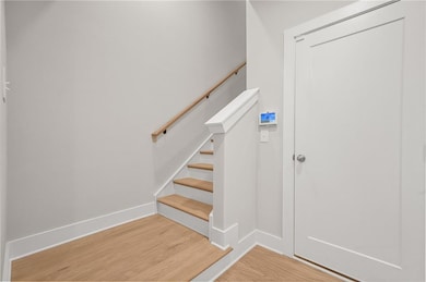 Staircase featuring wood finished floors and baseboards