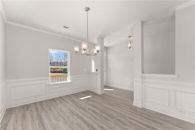 Stock PhotoUnfurnished dining area with a chandelier, wainscoting, light wood-style floors, crown molding, and a decorative wall