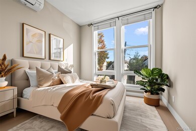 Bedroom featuring an AC wall unit and light wood finished floors