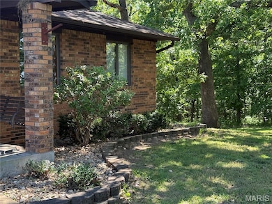 View of property exterior with brick siding and a lawn