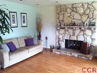 Inviting living room has full rock fireplace for e