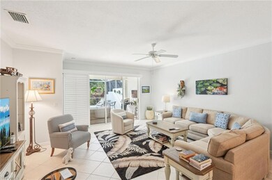 Living room featuring a ceiling fan, light tile pa
