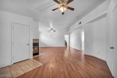 Unfurnished living room with ceiling fan, a tile f