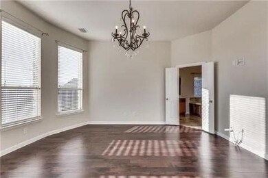 Spare room featuring dark hardwood / wood-style flooring and a chandelier