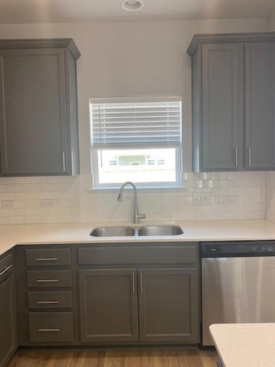 Kitchen featuring dishwashing machine, wood finis
