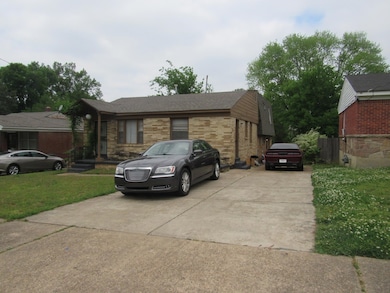 View of front facade with driveway, a front lawn, and brick siding