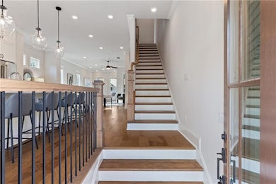 Stairs featuring ornamental molding, ceiling fan, wood finished floors, and recessed lighting