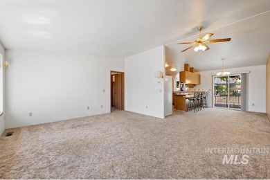 Living area featuring ceiling fan, light colored carpet, and vaulted ceiling