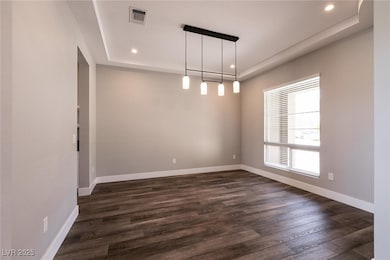 Unfurnished room with a raised ceiling, recessed l