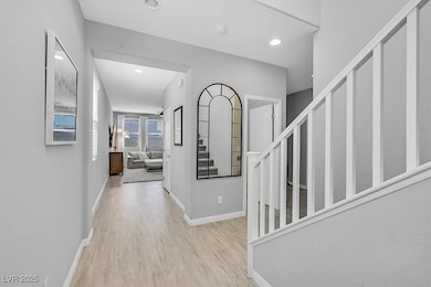 Hall featuring light wood-style flooring, stairway, and recessed lighting