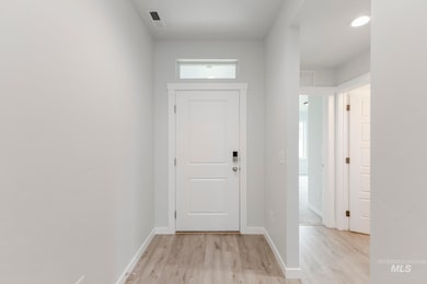 Foyer entrance with light wood-type flooring and baseboards