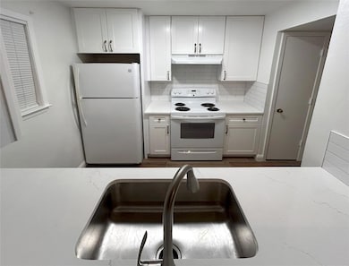 Kitchen with sink, white appliances, white cabinet