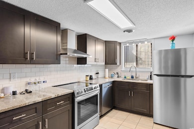 Kitchen with wall chimney exhaust hood, dark brown