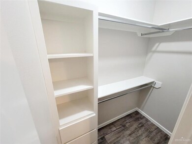 Walk in closet featuring dark wood-type flooring