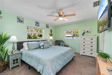 Carpeted bedroom featuring a textured ceiling and ceiling fan