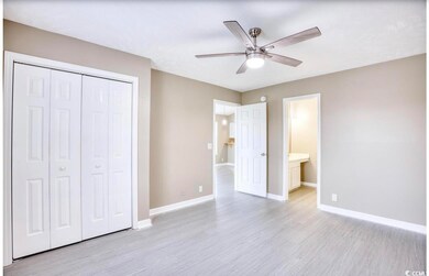 Unfurnished bedroom featuring ceiling fan, ensuite