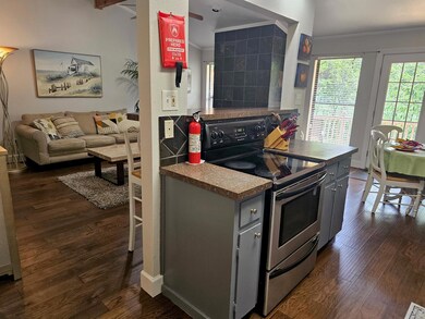 Kitchen featuring dark wood-style floors, open floor plan, stainless steel electric range