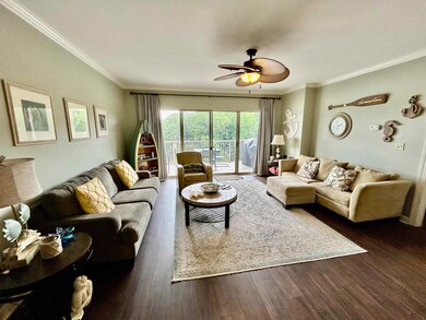 Living area featuring ornamental molding, a ceiling fan, and dark wood finished floors