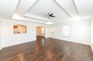 Unfurnished living room featuring a tray ceiling,