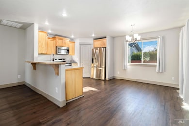 Kitchen with light countertops, light brown cabinets, appliances with stainless steel finishes, a chandelier, and recessed lighting