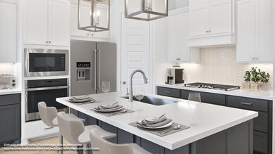 Kitchen with backsplash, appliances with stainless steel finishes, white cabinetry, gray cabinetry, and light stone countertops