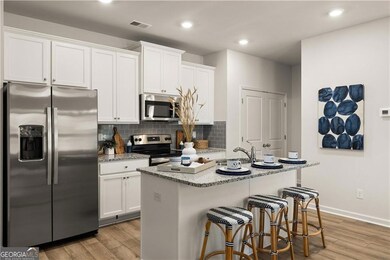 Kitchen with stainless steel appliances, white cab