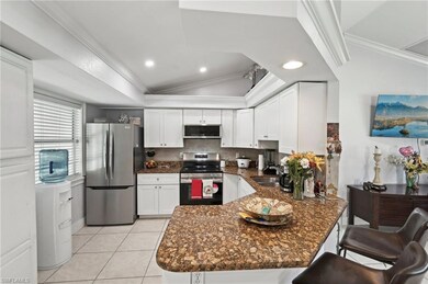 Kitchen featuring lofted ceiling, ornamental molding, backsplash, and appliances with stainless steel finishes
