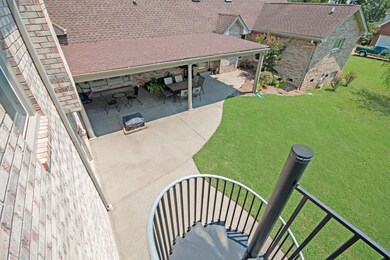 A Huge media room is over a section of garage that expands to cover about 3 of the garages. This is the view from the circular staircase, looking down on the Covered Patio for entertaining. 