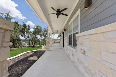 Porch with ceiling fan and a lawn