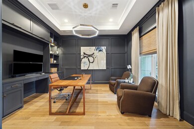 Just off the foyer, the dedicated home office offers a refined workspace with custom built-in cabinets, providing both style and functionality in a private, yet easily accessible setting and overlooks the front of the home.