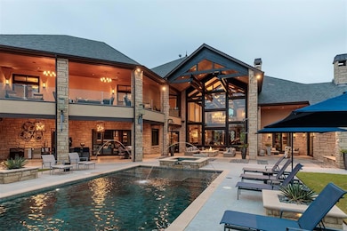 Back of house with a shingled roof, a balcony, a p