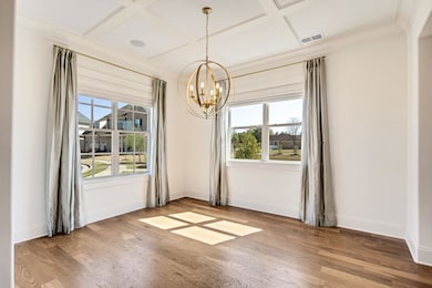 Unfurnished dining area with coffered ceiling, bas