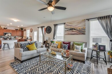 Living room featuring ceiling fan, light wood-type