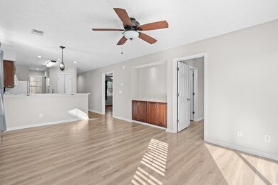 Unfurnished living room with ceiling fan, light ha