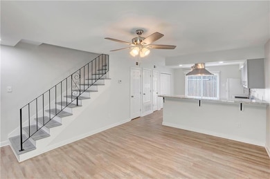 Overview of kitchen from living room; stairs leading to bedrooms