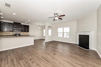 Unfurnished living room with a sink, a ceiling fan