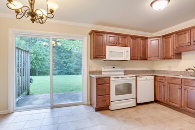 Updated kitchen with newer lighting, cabinets, and eat-in space overlooking the patio and green space