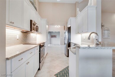 Kitchen with white cabinets, sink, light tile patt