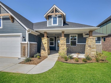 Craftsman inspired home featuring covered porch, a front lawn, a shingled roof, and brick siding