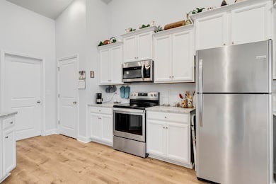Kitchen with stainless steel appliances, white cab