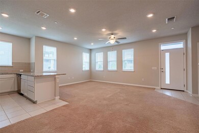 Kitchen with light colored carpet, light tile pat
