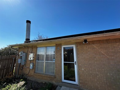 Back of property featuring brick siding and fence