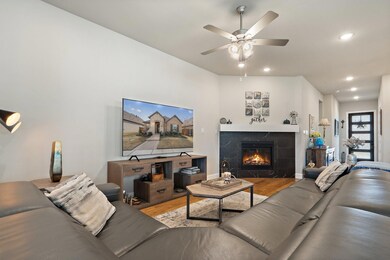 Living room with ceiling fan, a fireplace, and har