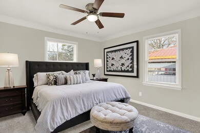 Bedroom featuring light carpet, baseboards, and a ceiling fan