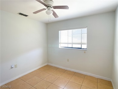 Empty room featuring light tile patterned floors and a ceiling fan