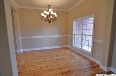 Large picture window, chair railing, crown molding, and pillars separating the room.