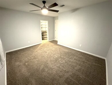 Spacious master bedroom with plush carpeting and m