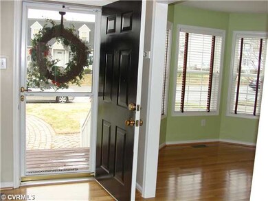 Foyer - Glossy Hardwood floors flow from the foyer